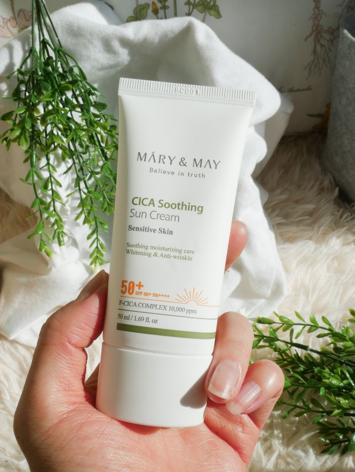 A detailed shot of a hand holding a CICA Soothing Sun Cream tube, ideal for skincare promotions.